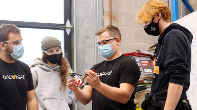 Mitch Gregory (center) and the FSAE team building electric car